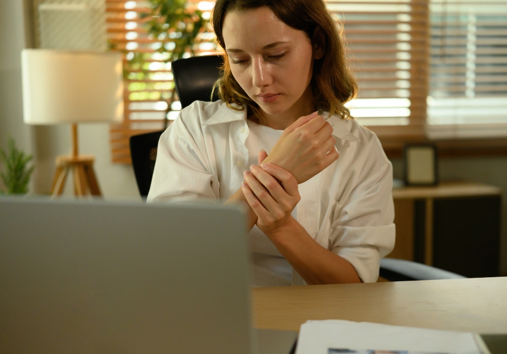 O “Passivo Físico” do Home Office: Por que as dores no punho explodiram em 2026?